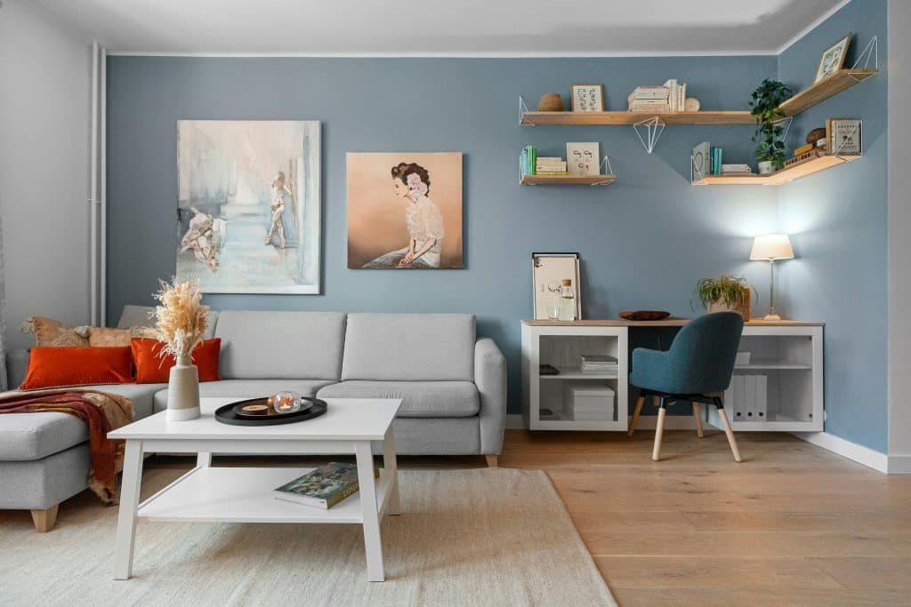 A living room filled with furniture and a painting on the wall