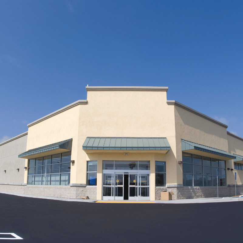 Professional painter applying exterior paint to commercial building in South Amboy